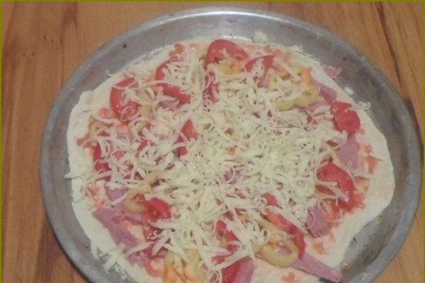 Насыпать тертый сыр в пиццу